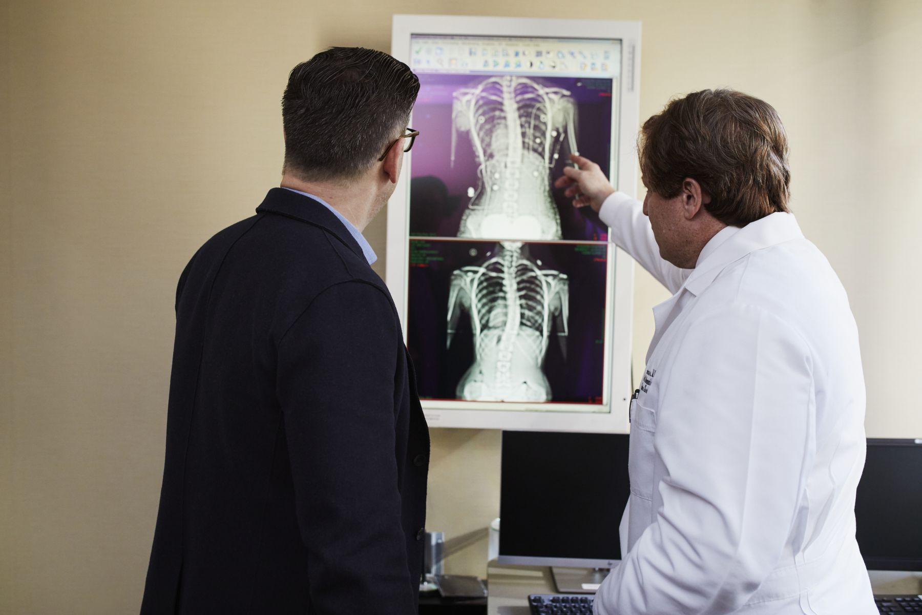 Deux médecins examinent radiographie affichée dans cabinet de consultation