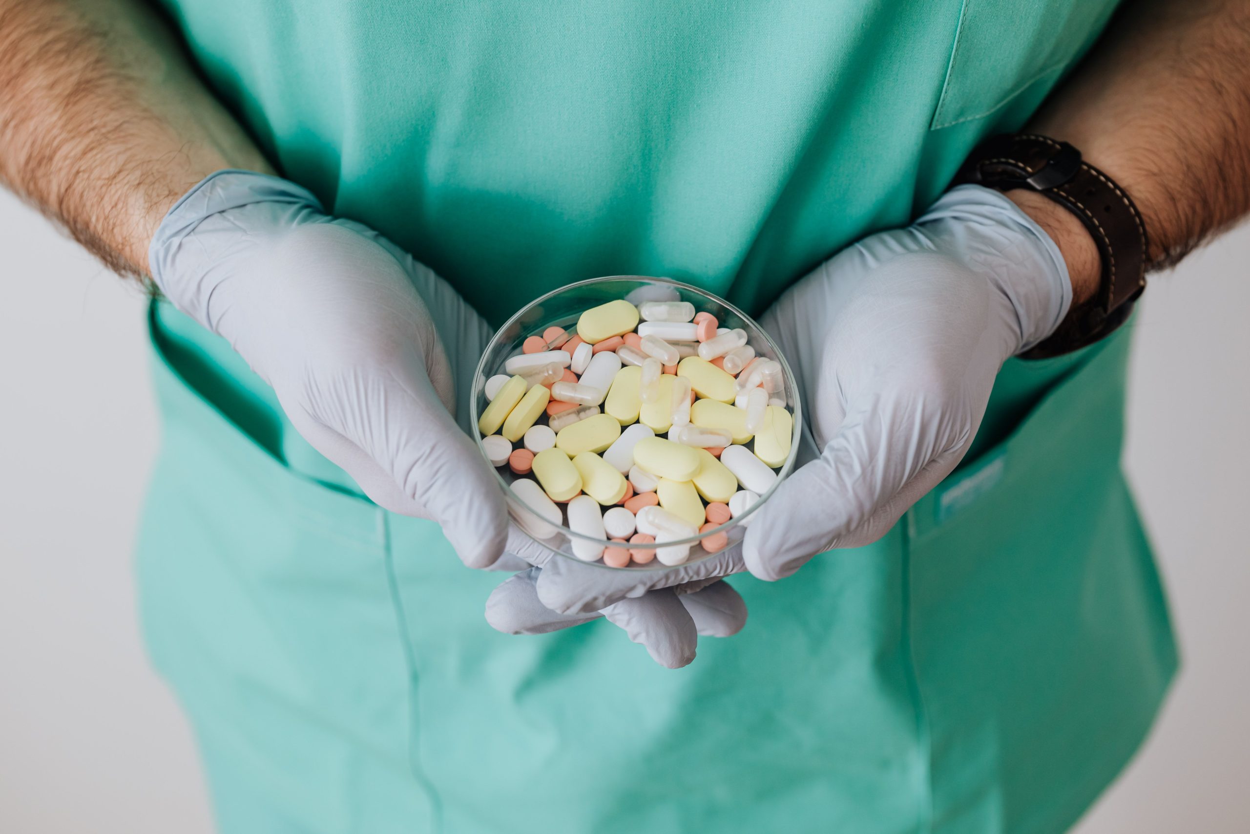 Médecin tenant un bol de médicaments colorés
