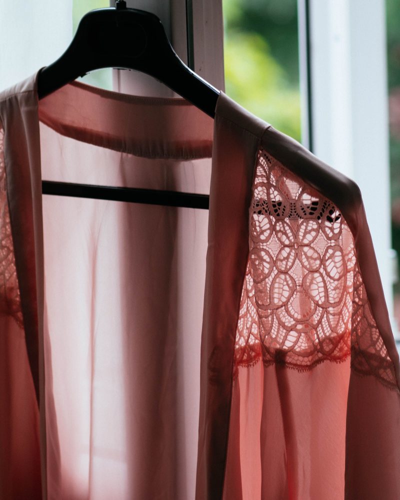 Kimono en dentelle rose suspendu près d'une fenêtre