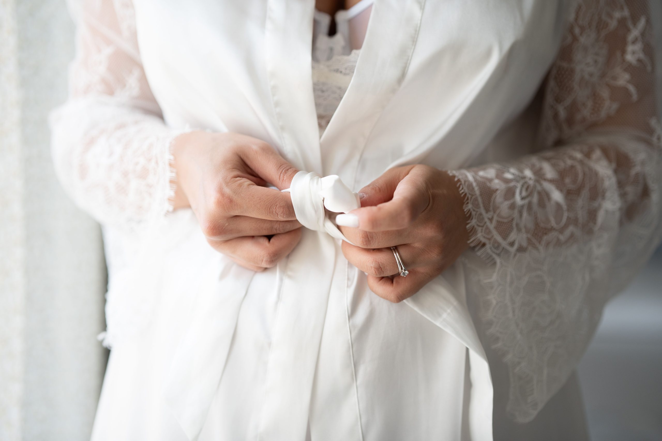 Femme nouant sa robe de chambre en dentelle blanche