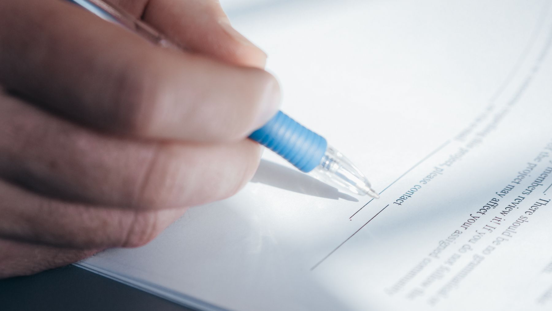 Stylo bleu reposant sur document signé en gros plan