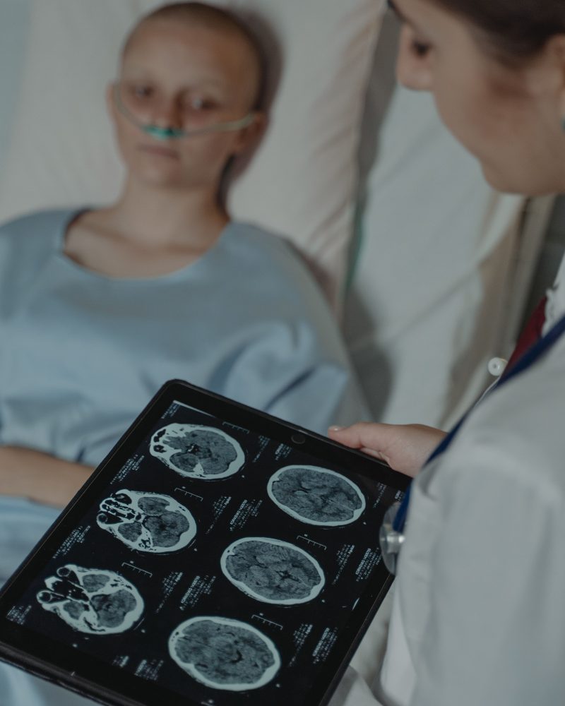 Médecin analysant des scanners cérébraux près d'un patient